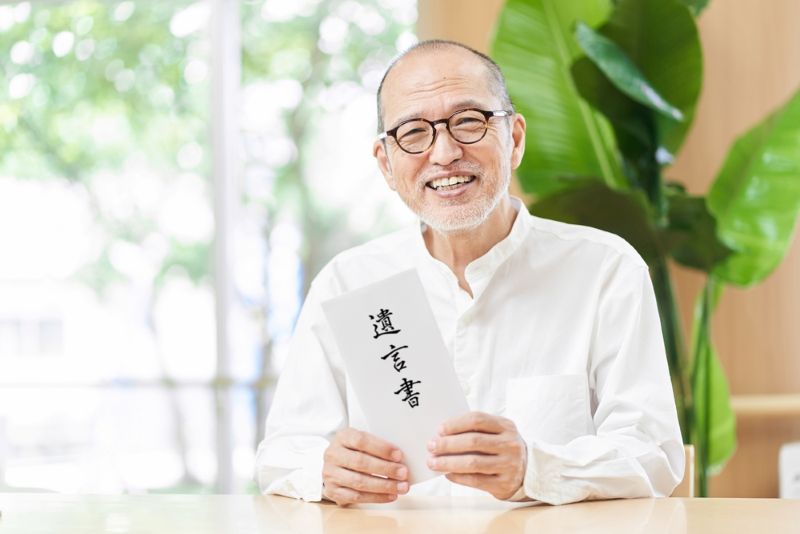 遺言書を手に持った高齢者の写真